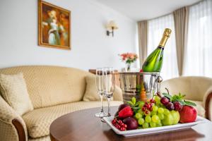 a table with a plate of fruit and a bottle of wine at Hotel Lubicz in Ustka