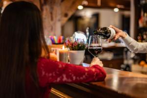a woman pouring a glass of wine at a bar at Hotel Lubicz in Ustka