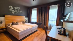 a bedroom with a bed and a desk in it at arte Hotel Wien Stadthalle in Vienna