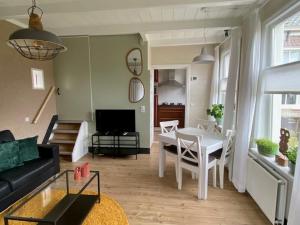 a living room with a couch and a table and chairs at B & Buitenlust in Schagerbrug