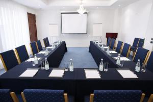 a conference room with tables and chairs and a screen at Brommavik Hotel in Stockholm