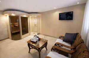 a living room with a couch and a tv on the wall at Brommavik Hotel in Stockholm