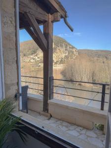 a balcony with a view of a river and mountains at La Terrasse sur La Roque-Gageac in Vézac