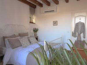 a bedroom with a white bed and a plant at La Terrasse sur La Roque-Gageac in Vézac