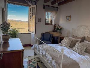 a bedroom with a bed and a desk and a window at La Terrasse sur La Roque-Gageac in Vézac
