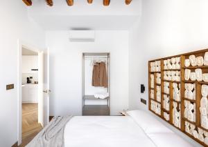 a bedroom with white walls and a bed with a wooden headboard at Apartamentos El Marqués in Granada