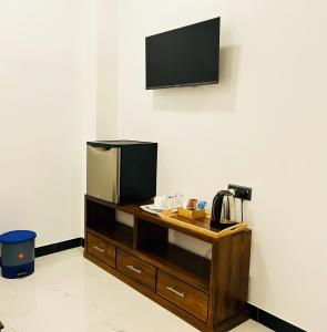 a room with a desk with a television on a wall at Nushi Inn in Katunayaka