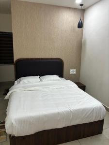 a bedroom with a large bed with white sheets at KOTTOOR LODGE Parakode in Adūr