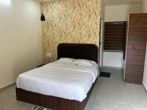 a bedroom with a large bed with white sheets at KOTTOOR LODGE Parakode in Adūr