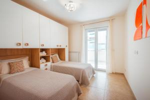a bedroom with two beds and a window at Velaria Boutique Apartment in Monopoli