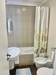 a bathroom with a sink and a tub and a toilet at Paradise in Costa da Caparica +14 photos