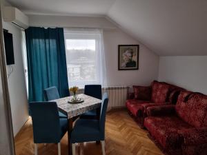 a living room with a table and a couch at Sunčani Breg Apartments Vrdnik in Vrdnik