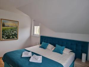 a bedroom with a blue bed with two pillows on it at Sunčani Breg Apartments Vrdnik in Vrdnik +110 photos