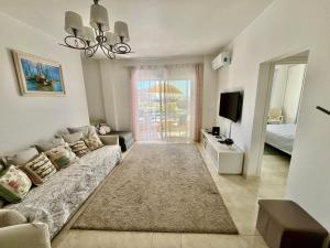 a living room with a couch and a television at Paradise in Costa da Caparica