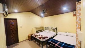 a room with two beds and a door in it at Gokarna Beach Vibes in Gokarn