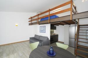 a living room with a table and a loft bed at Appartamenti Pratone in Garda +73 photos