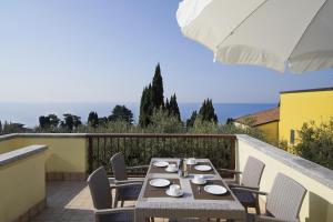 a table and chairs on a balcony with the ocean at Appartamenti Pratone in Garda