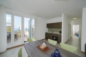 a kitchen and dining room with a table and chairs at Appartamenti Pratone in Garda