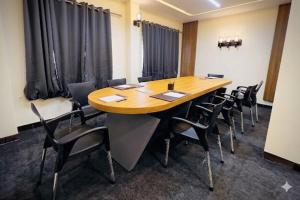 a conference room with a large wooden table and chairs at Skylora Heights Inn in Kozhikode