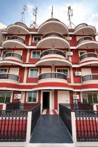 a large red building with balconies on it at Skylora Heights Inn in Kozhikode