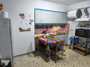 a kitchen with a table and a refrigerator at Studio By The Beach 2 in Saronida +2 photos