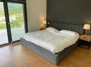 a large bed in a bedroom with a large window at Faro de Gredos in Arenas de San Pedro