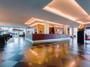 a lobby of a hotel with a reception desk at MÖVENPICK Hotel Stuttgart Airport in Leinfelden-Echterdingen