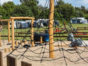 a playground with a swing set in a park at DCU-Camping Kulhuse in Kulhuse +5 photos