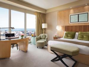 a hotel room with a bed and a desk with a computer at Mövenpick Hotel Al Khobar in Al Khobar