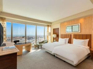 a hotel room with a large bed and a desk at Mövenpick Hotel Al Khobar in Al Khobar