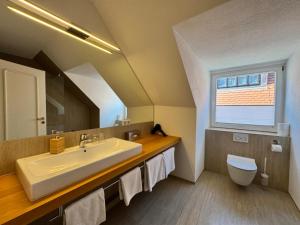 a bathroom with a sink and a toilet and a window at Hotel Spiegel Garni in Lindau +36 photos