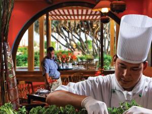 a man in a chefs hat preparing food in a restaurant at Movenpick Resort Taba in Taba +231 photos