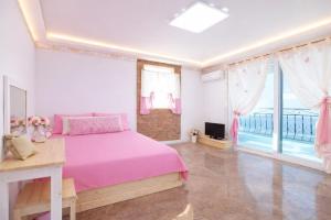 a bedroom with a pink bed and a large window at Danyang paramaeul in Danyang
