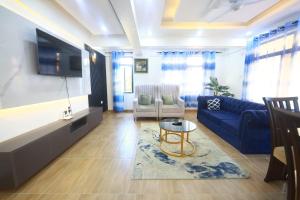 a living room with a blue couch and a table at Topaz Apartments Shanzu in Mombasa