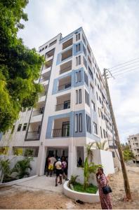 a group of people standing in front of a tall building at Topaz Apartments Shanzu in Mombasa +1 photo