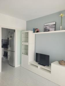 a white kitchen with a refrigerator and a tv at Torrenostra PLATJA in Torrenostra +9 photos