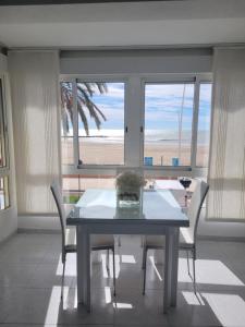 a table and chairs in a room with a view of the beach at Torrenostra PLATJA in Torrenostra