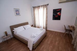 a bedroom with a bed with white sheets and a window at Naxian Harmony 300m from the beach in Naxos Chora +25 photos