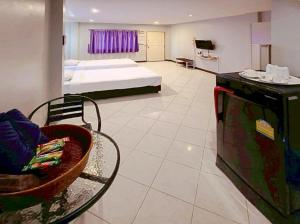 a bedroom with a bed and a chair in a room at V Village Hotel Saraburi in Ban Muak Lek