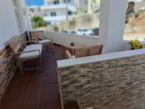 a balcony with chairs and tables and a window at Naxian Harmony 300m from the beach in Naxos Chora