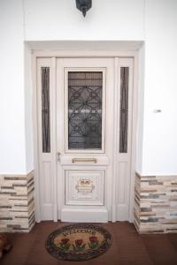 a white door with a window and a rug at Naxian Harmony 300m from the beach in Naxos Chora