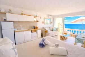 a kitchen and living room with a view of the ocean at Vue mer & terrasse Studio calme parking St Raphaël in Saint-Raphaël
