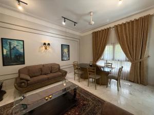 a living room with a couch and a table at Ghumo - 10BR Villa in Bahadurabad near Aga Khan in Karachi