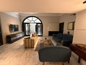 a living room with a couch and a tv at Ghumo - 10BR Villa in Bahadurabad near Aga Khan in Karachi