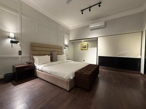 a bedroom with a bed and a chair in it at Ghumo - 10BR Villa in Bahadurabad near Aga Khan in Karachi