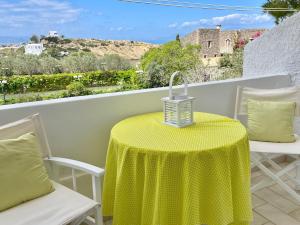 a table with a yellow table cloth on a balcony at ZEN, Oneiropagida, Aegina in Vathí +20 photos
