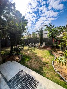 a backyard with a bunch of chairs and trees at Ghumo - 10BR Villa in Bahadurabad near Aga Khan in Karachi