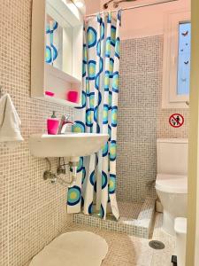 a bathroom with a sink and a shower curtain at ZEN, Oneiropagida, Aegina in Vathí