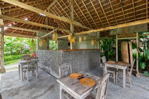 a patio with tables and chairs in a building at Abipraya Ubud in Ubud