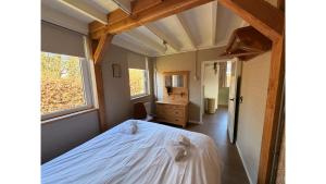 a bedroom with a bed with two towels on it at Bungalow Doris with Hot Tub | 4 persons in Gasselte